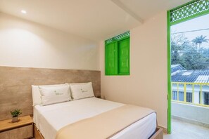 A bedroom with a bed, a nightstand, a green window shutter, and a view of the outside. - Hotel Green House (Salento)