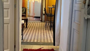 A hallway with a patterned floor, a red carpet, and a dining area with chairs and a table. - Rooftop del quinto (Fès)