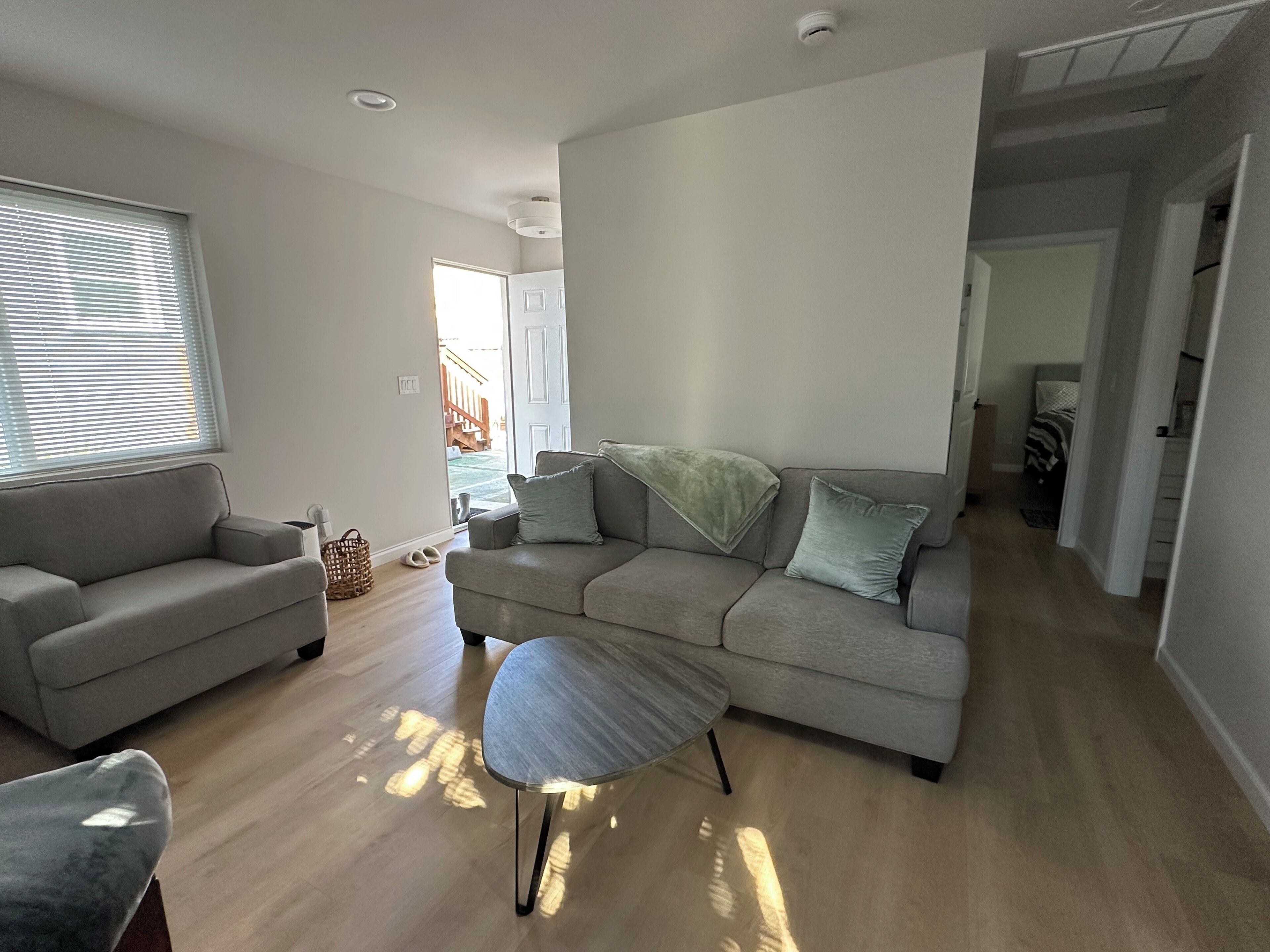 Un salon moderne avec un canapé, un fauteuil et une petite table.