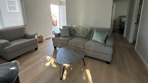 Ett modernt vardagsrum med en soffa, en fåtölj och ett litet bord.