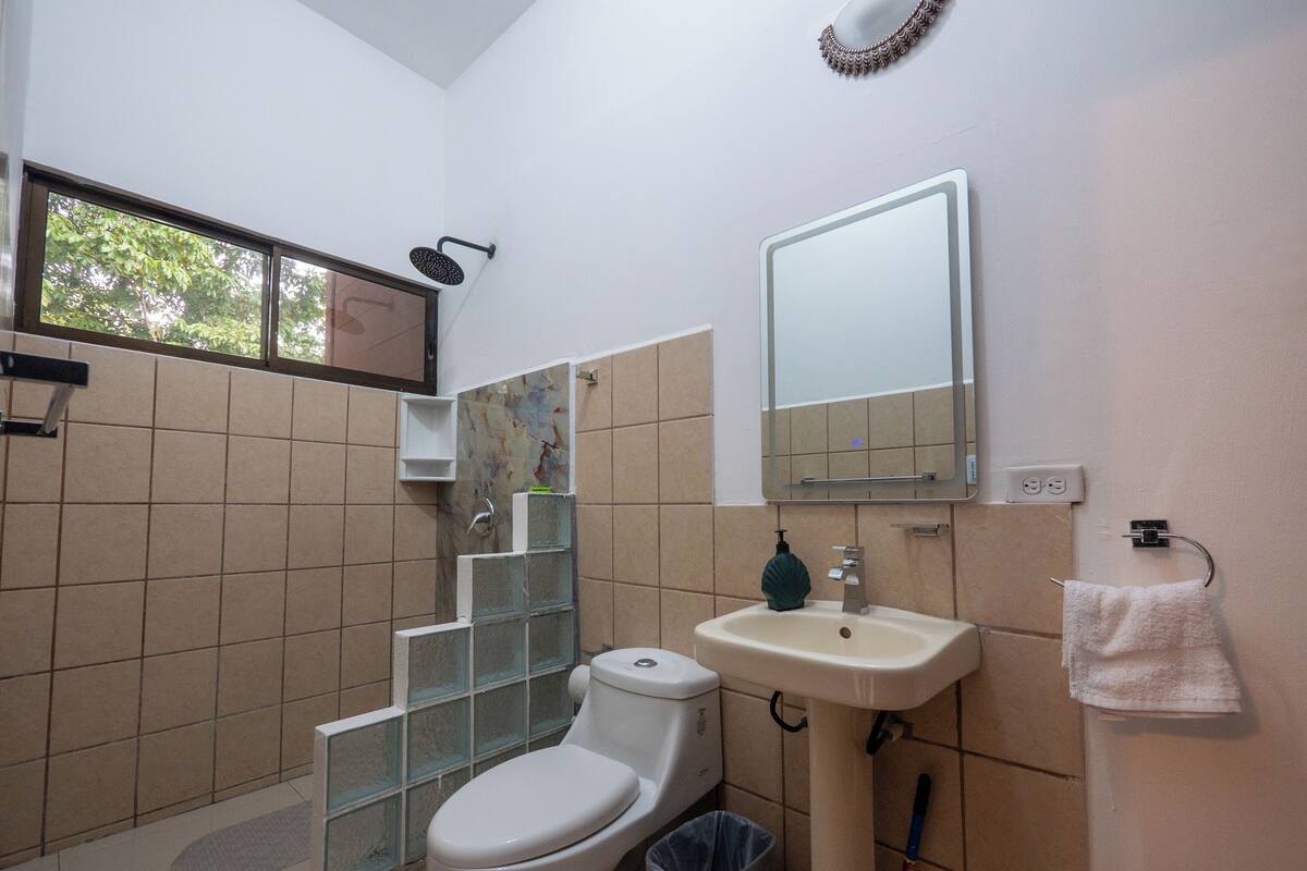 A bathroom with a toilet, sink, and shower.