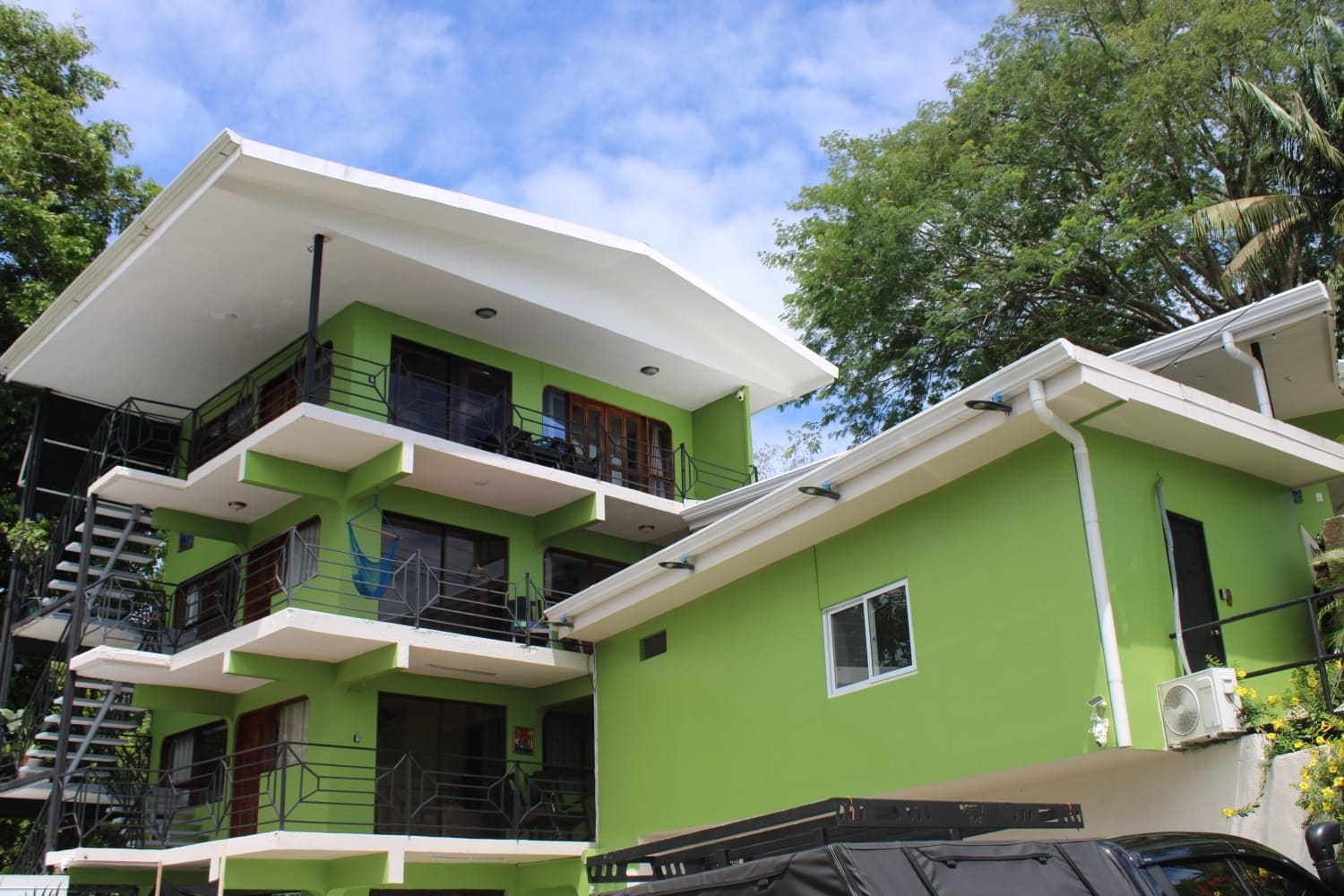 A multi-story building with balconies and a flat roof.