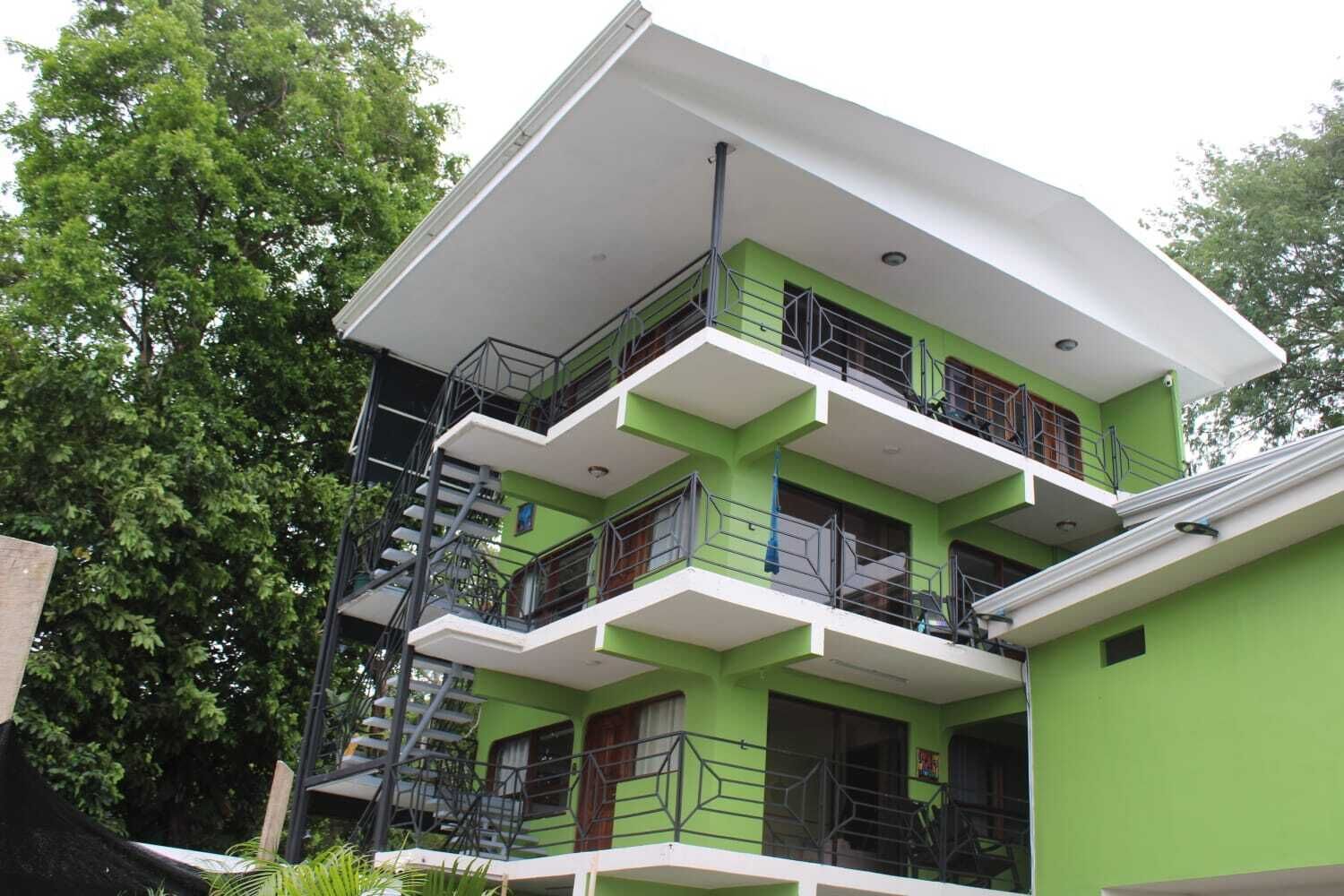 A multi-story building with balconies and a staircase.
