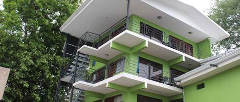A multi-story building with balconies and a staircase.