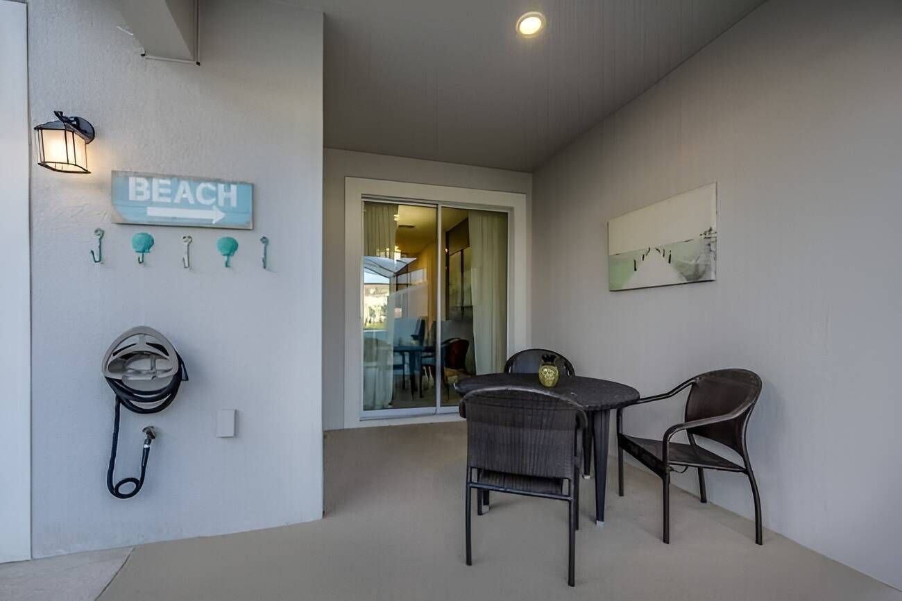 A modern room with a beach-themed sign, a helmet, and a table with chairs.