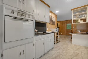 A modern kitchen with white cabinetry, a built-in oven, and a microwave. - Parkside at San Luis • 8 Beds • 5 Bedrooms • 2 Bathrooms in Hallway (Tallahassee)