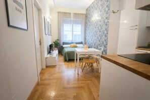 A compact living space with a kitchenette, a dining area, and a bedroom with a window. - Caralis Home is an elegant apartment just steps from Cagliari's historic sites.Ideal for families who want to enjoy a comfortable holiday in Cagliari's historic center, discovering its most fascinating secrets and traditions.Caralis Home is fully air-con (Cagliari)