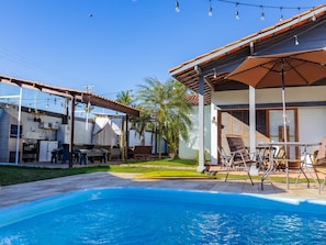 Una piscina techada, sombrillas, sillones reclinables de piscina