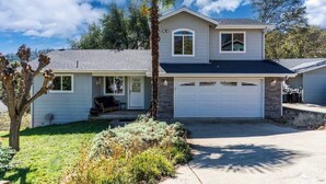 A two-story house with a garage, a covered porch, and a well-maintained lawn. - Yosemite Terrace View Retreat (Mariposa)