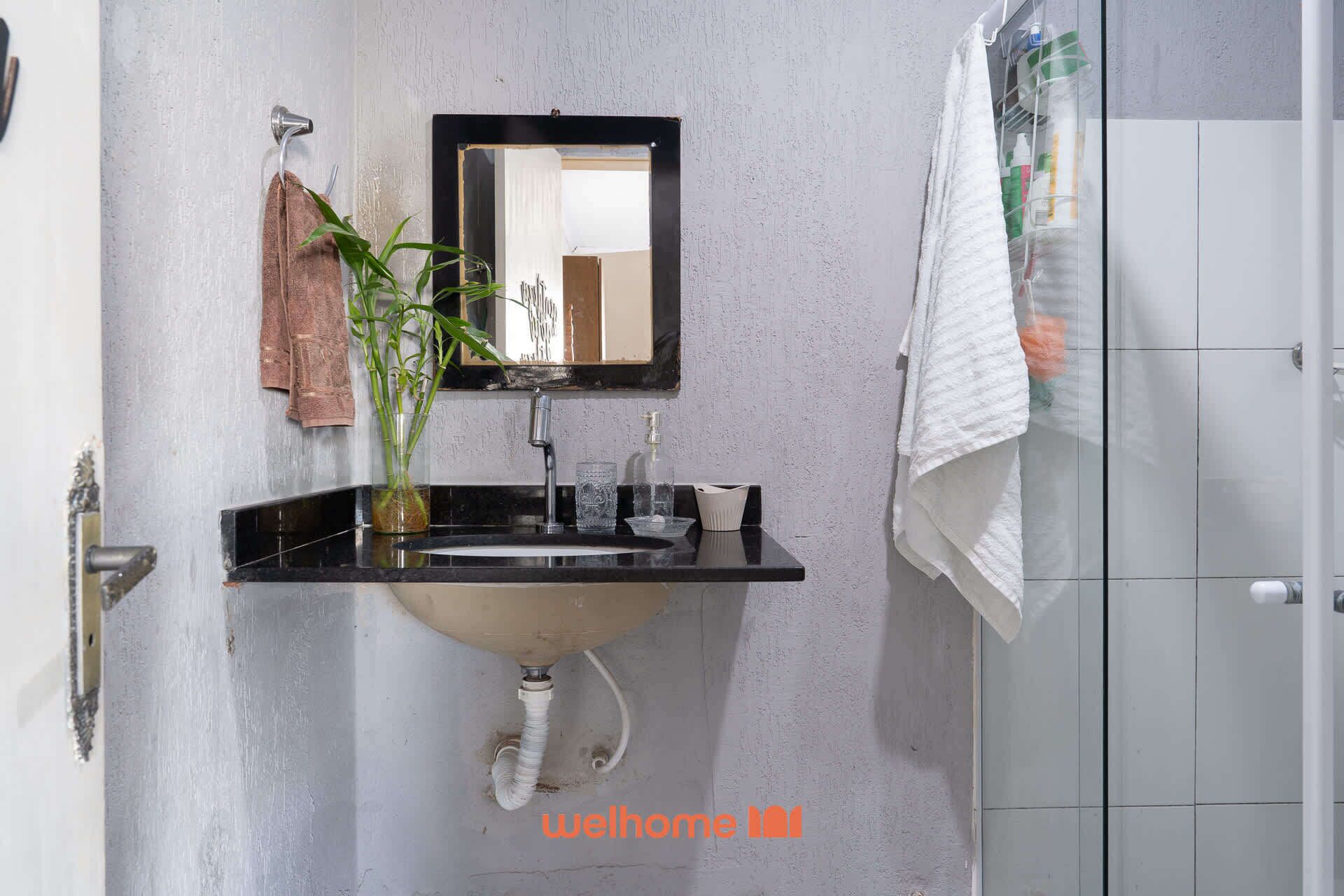 A bathroom with a sink, mirror, and towel rack.