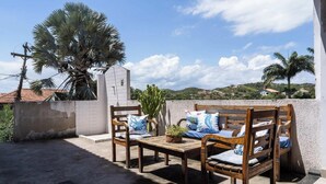 An outdoor seating area with wooden furniture and a cactus plant. - Casa em Buzios com Piscina perto da Praia (Armação dos Búzios)
