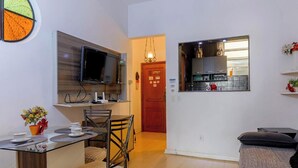 A compact living space with a dining area, kitchenette, and a TV mounted on the wall. - Apto no Rio a 200m da Praia de Copacabana (Rio de Janeiro)