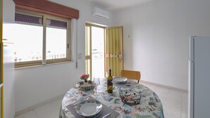 A dining area with a table set for two, a bottle of wine, and a decorative centerpiece. - 4 bedroom amazing apartment in Ferruzzano (Ferruzzano)