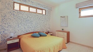 A bedroom with a bed, a nightstand, a dresser, a mirror, and a window. - 4 bedroom amazing apartment in Ferruzzano (Ferruzzano)