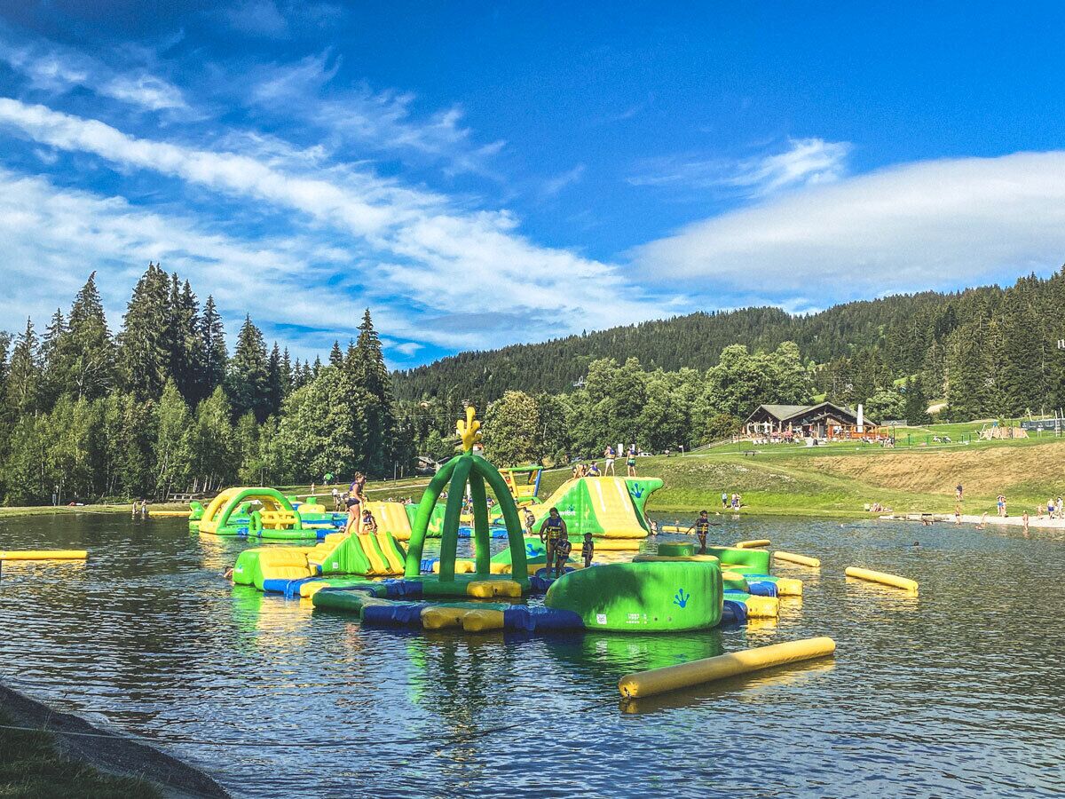 A water park with inflatable play structures and a lake.