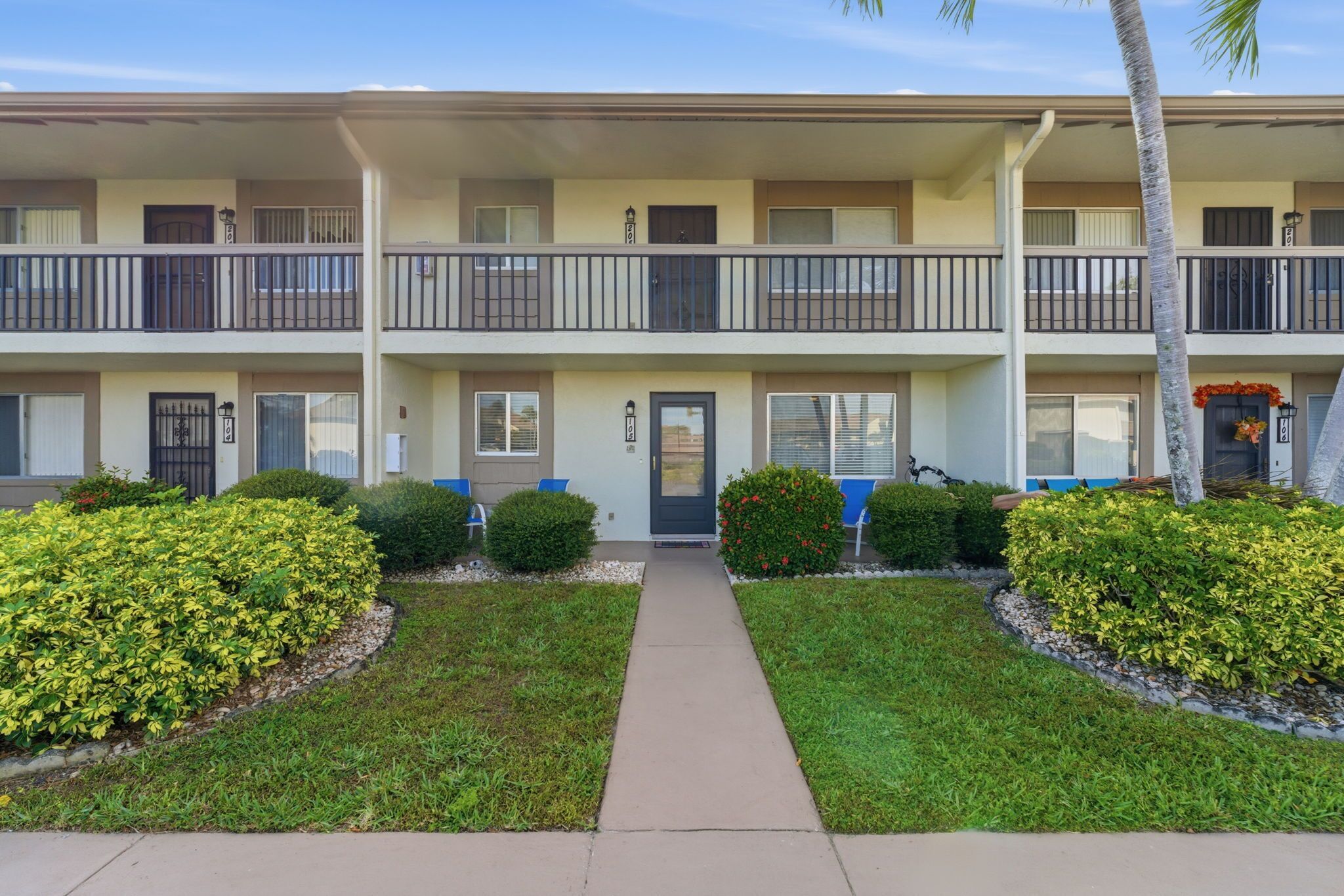 A multi-story apartment building with balconies, a central entrance, and well-maintained landscaping.