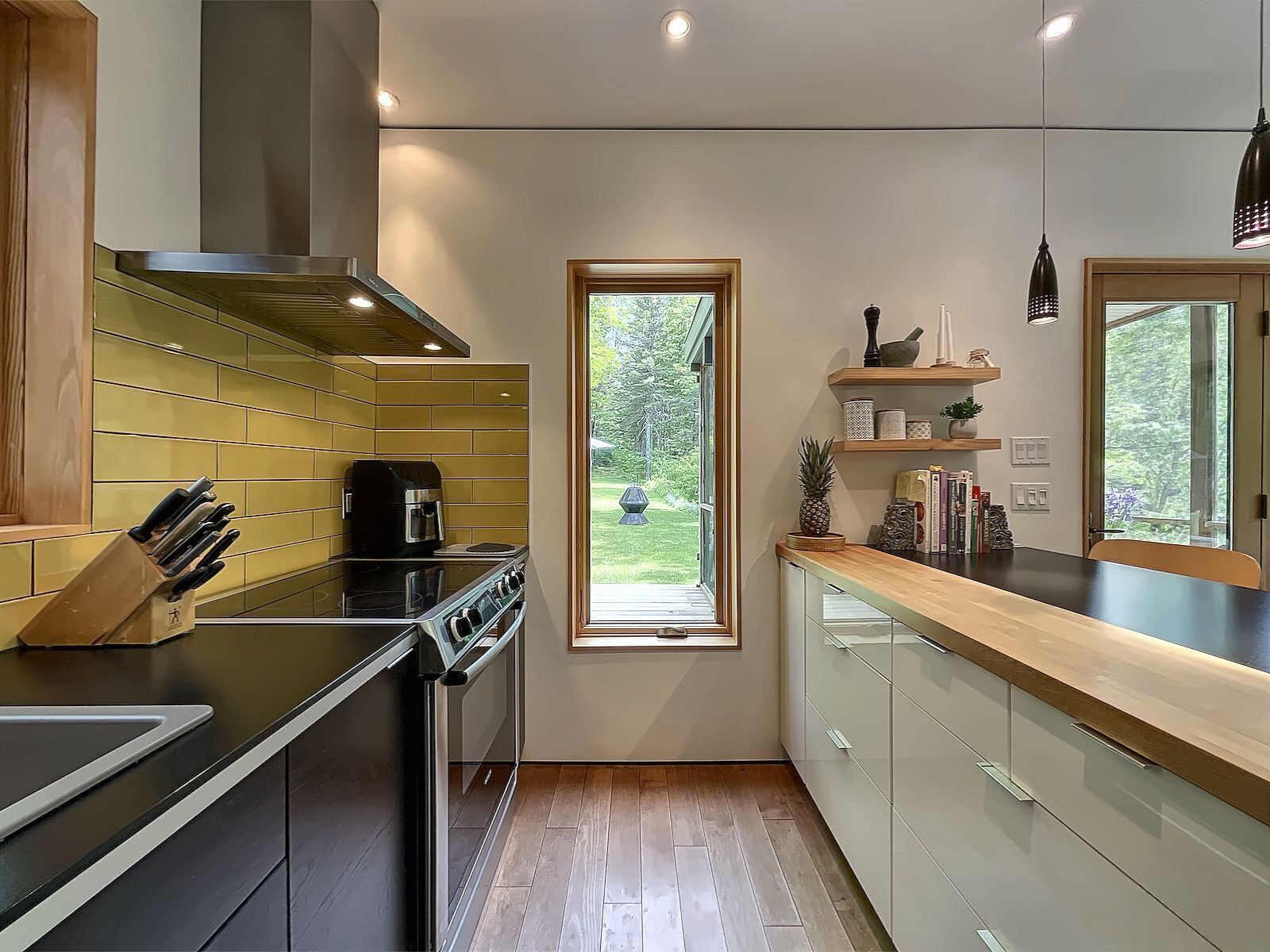 Une cuisine moderne équipée d  ’une cuisinière, d’une machine à café et d’une fenêtre donnant sur un jardin.