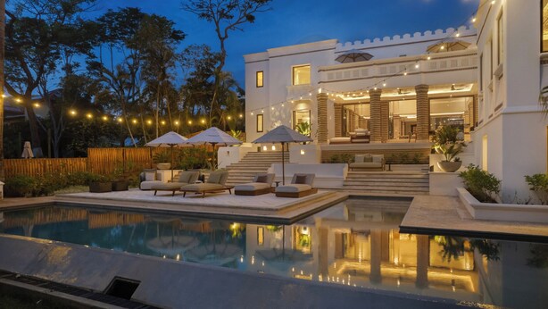 A modern house with a swimming pool, outdoor seating, and string lights. - The Luxurious Beach Front Villa Marrakech (Tamarindo)