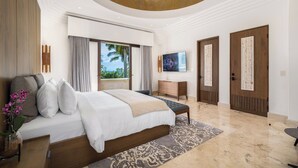 A modern bedroom with a large bed, a desk, and a television. - The Luxurious Beach Front Villa Marrakech (Tamarindo)