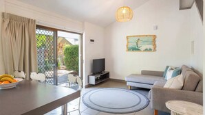 Ein modernes Wohnzimmer mit einer Couch, einem Fernseher und Kunstwerken an der Wand.