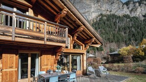 A wooden cabin with a balcony overlooking a mountainous landscape.