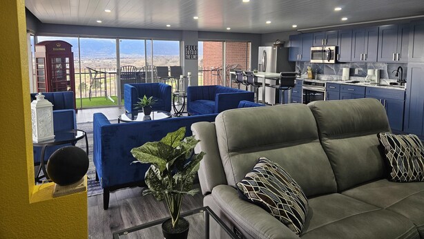 A modern living area with a sofa, chairs, a dining table, and a kitchen. - 1 Bedroom Luxurious Loft perfect for Entertaining! (Colorado Springs)