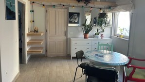 Een moderne keuken met een houten deur, witte kasten en een ronde tafel met stoelen.