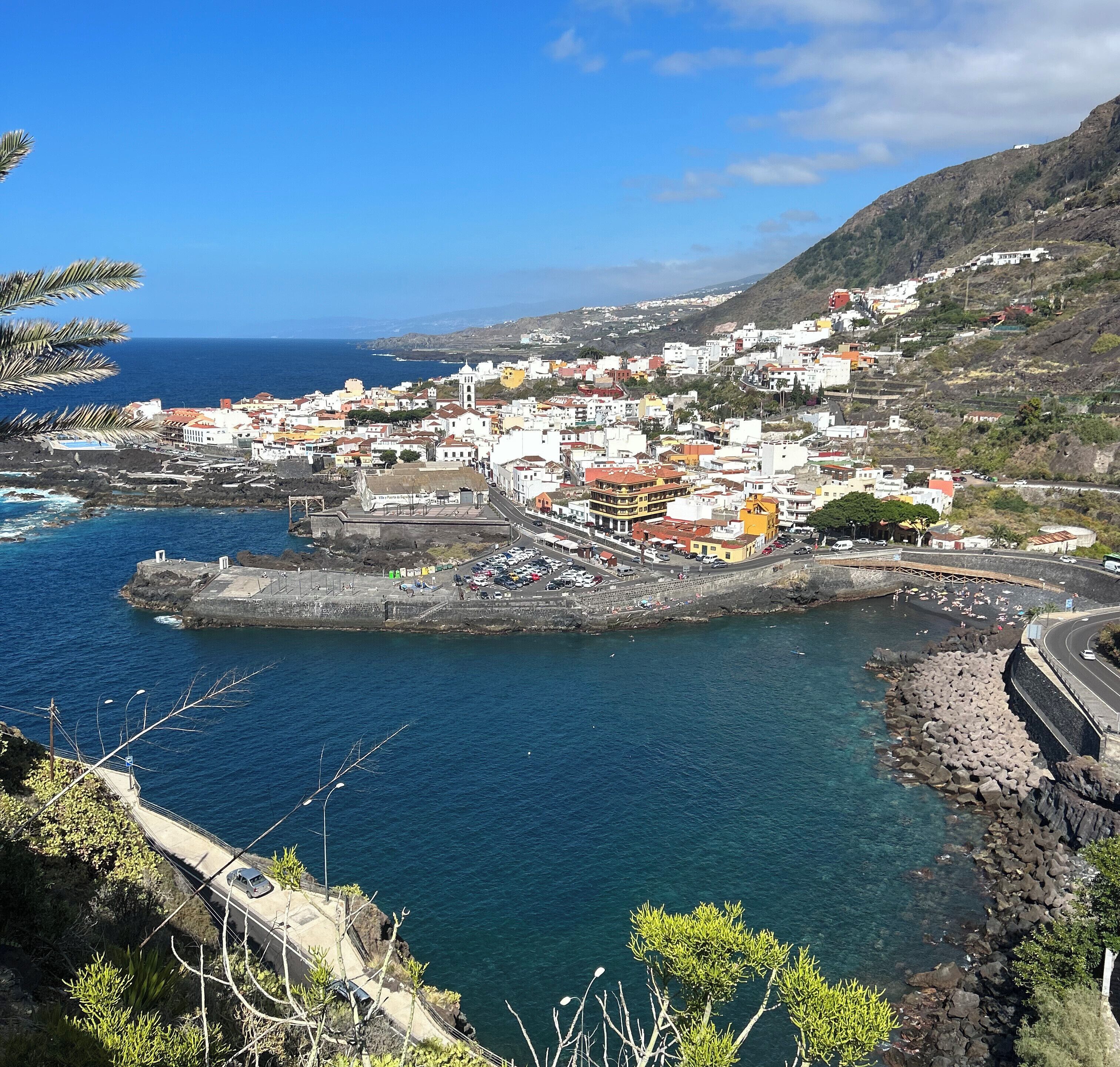 A coastal town with a prominent church, a rocky harbor, and a mix of residential and commercial buildings.