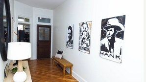 A hallway with a wooden bench, a white lamp, and three black-and-white artwork on the wall. - GOOD HABIT Spacious 4-bedroom loft apartment on the square in Springfield, TN (Springfield)