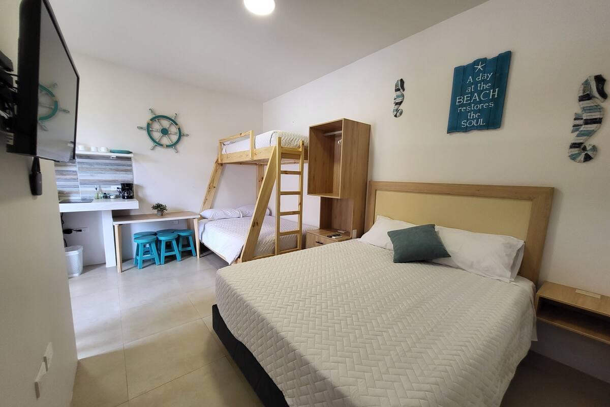 A bedroom with a bunk bed, a desk, and a chair. There is a wall clock and a motivational quote on the wall.