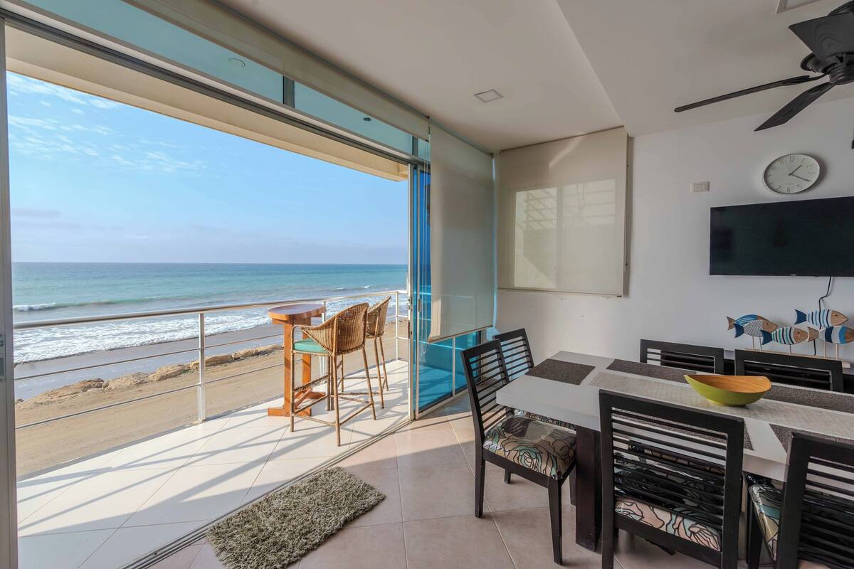 A dining area with a view of the beach and ocean.