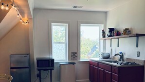 A kitchen with a refrigerator, microwave, and stove. There are two windows and a ceiling light. - Cozy Mother-In-Law Suite (Pittsburgh)