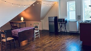 A compact kitchen with a dining area, featuring a refrigerator, microwave, and a gas stove. - Cozy Mother-In-Law Suite (Pittsburgh)