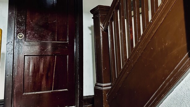 A wooden staircase with a handrail and a dark wooden door with a glass panel. - Cozy Mother-In-Law Suite (Pittsburgh)