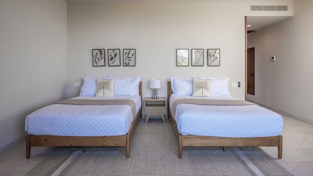 A double room with two beds, a small bedside table with a lamp, and a wall-mounted air vent. - Penthouse Arenamar in Punta Mita (Punta de Mita)