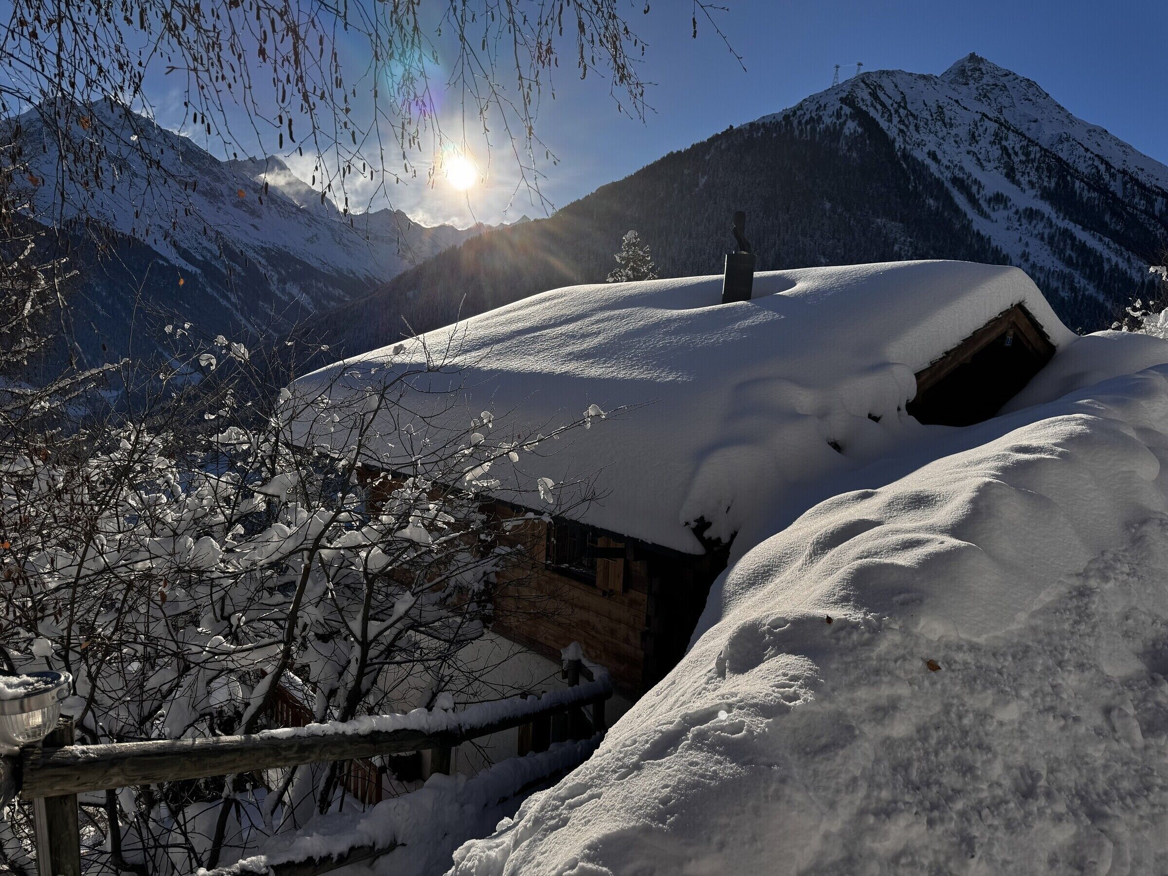 Eine verschneite Berglandschaft mit einer Holzhütte.