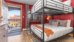 Een slaapkamer met stapelbed en uitzicht op gebouwen.