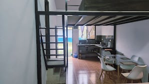 Una cocina moderna con zona de comedor, que cuenta con un gran ventanal, horno empotrado y un lavamanos.