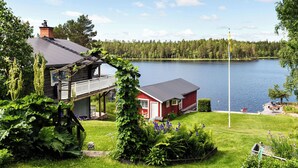 Une propriété au bord du lac, comprenant une maison, un quai et un jardin.