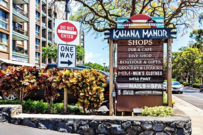 A sign for Kahana Manor with a list of shops including a pub, dine shop, boutique, and more. - Bright stylish living by the Seaside (Kahana)