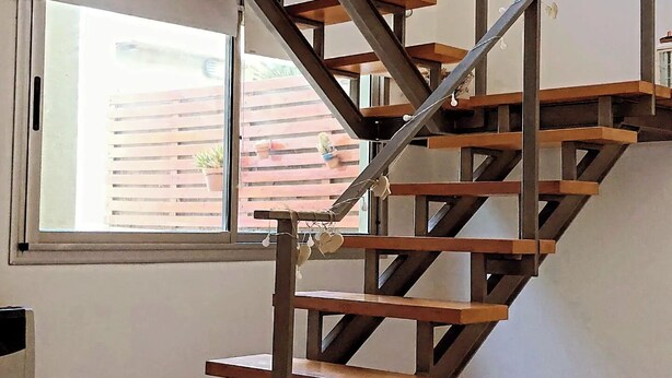 A staircase with wooden steps and metal railings, leading to an upper floor. - Splendid house, very bright, 3 bedrooms, 3 bathrooms, kitchen, barbecue. Courtyard (Chascomús)
