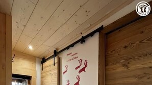 A wooden interior hallway with a wall-mounted sign featuring deer silhouettes and text. - La Liete - 1st Floor (BESSANS)