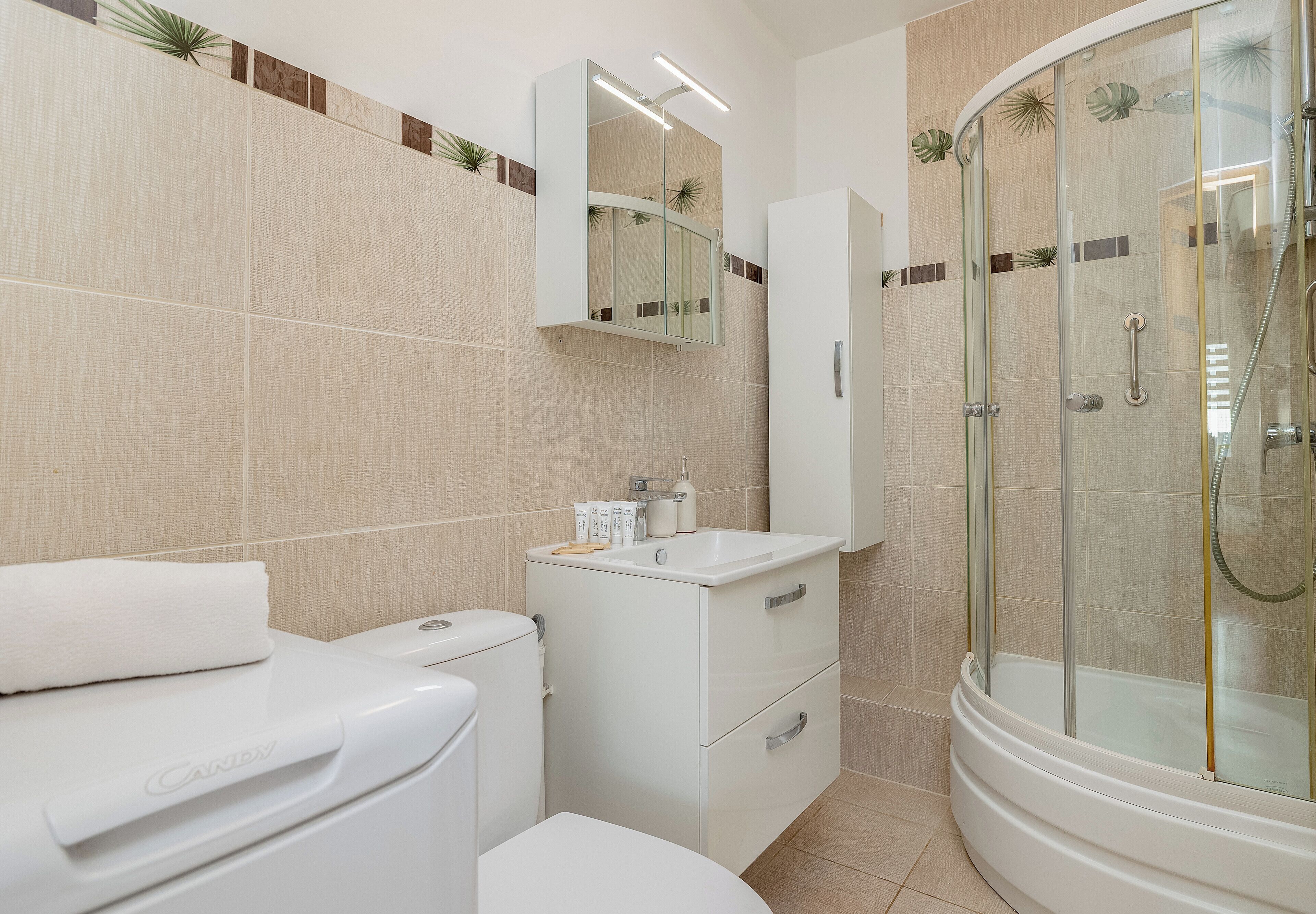 Une salle de bain moderne équipée de toilettes, d’un lavabo et d’une douche.