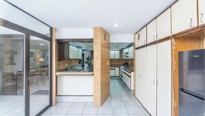 A modern kitchen with a central island, white cabinets, and a stainless steel refrigerator. - Family Home with Heated Pool (Guadalajara)