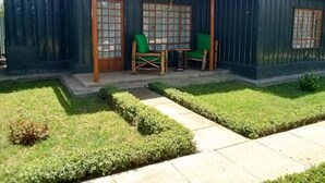 Un bâtiment doté d’un espace extérieur abrité avec des sièges, une petite table et deux chaises.
