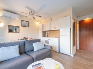 A modern living room with a grey sofa, a white coffee table, and a ceiling fan. - 1-Br Apartment Near the Beach and the Croisette, Palm Beach (Cannes)