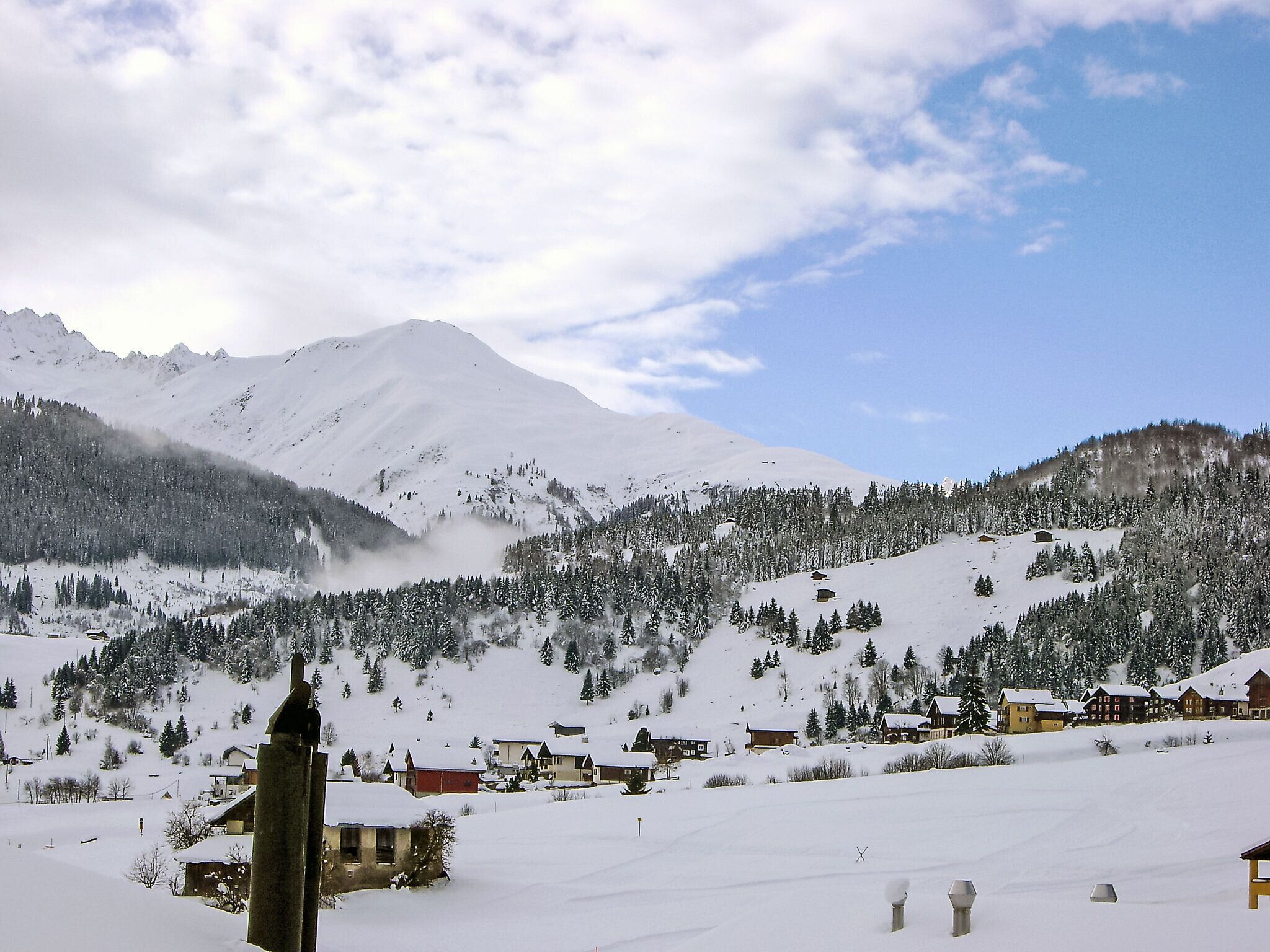 A snow-covered mountain village with houses and a church.