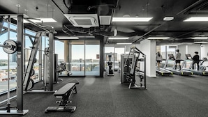 A gym with exercise equipment, treadmills, and a bench. - Luxe 1+1 Apt | Huge Balcony+BBQ  | Adelaide CBD (Adelaide)