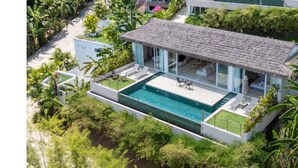 A modern house with a large swimming pool, surrounded by lush greenery and a thatched roof. - 180° Sea View Villa | Private Infinity Pool Bang Por Koh Samui (Koh Samui)