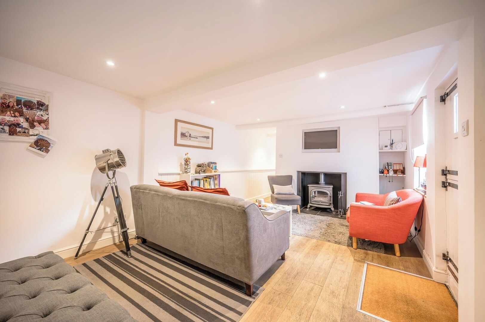 Una sala de estar con sofá, sillón y chimenea.